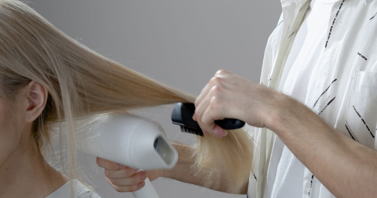 salon near me: stylist blow-drying a client's hair during a busy afternoon appointment